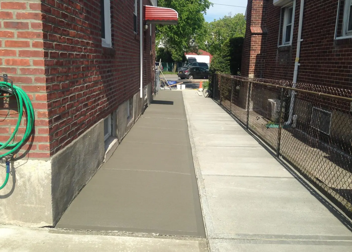 New concrete sidewalk completed alongside a brick home