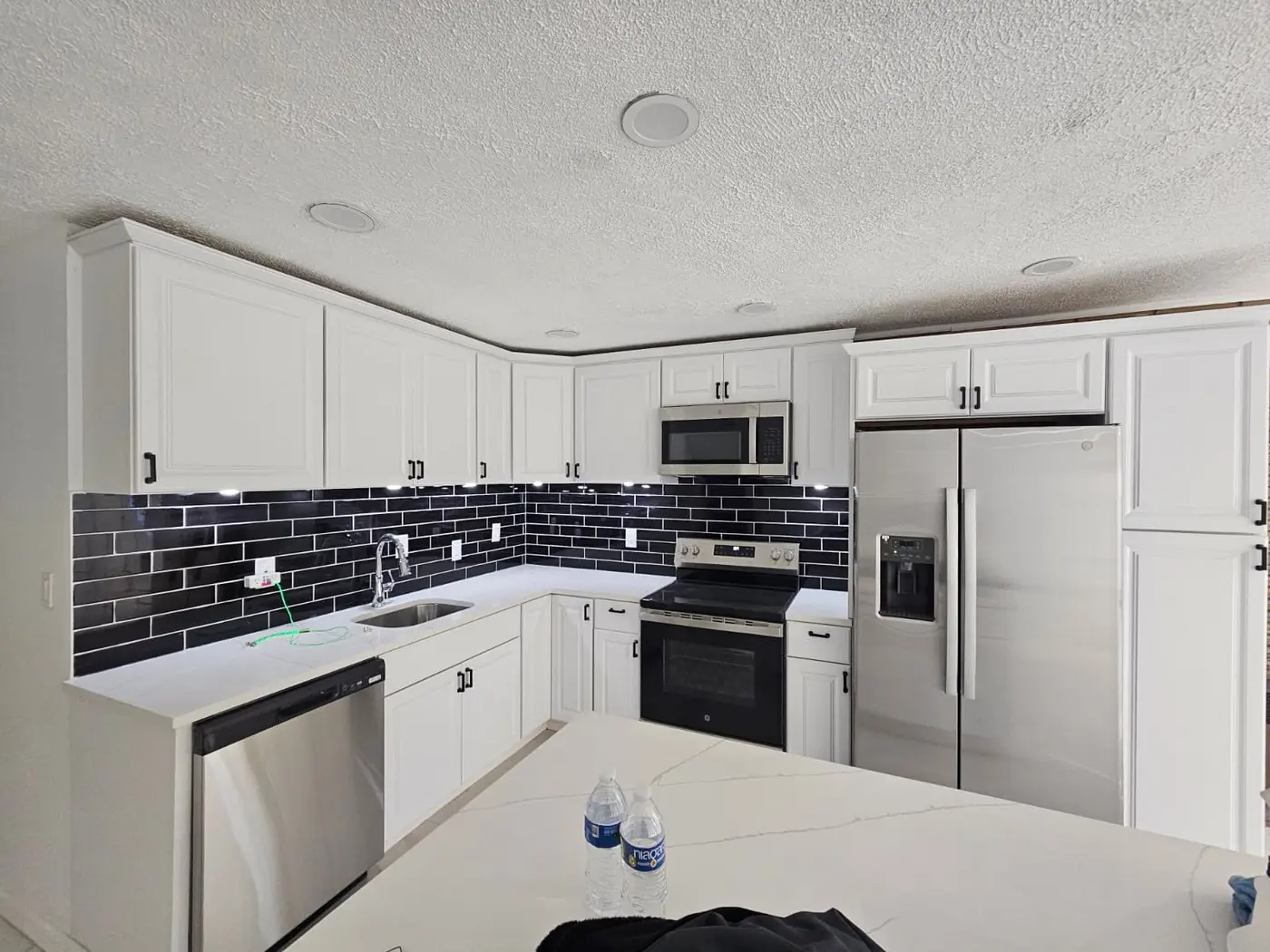 Completed white kitchen with black tile backsplash